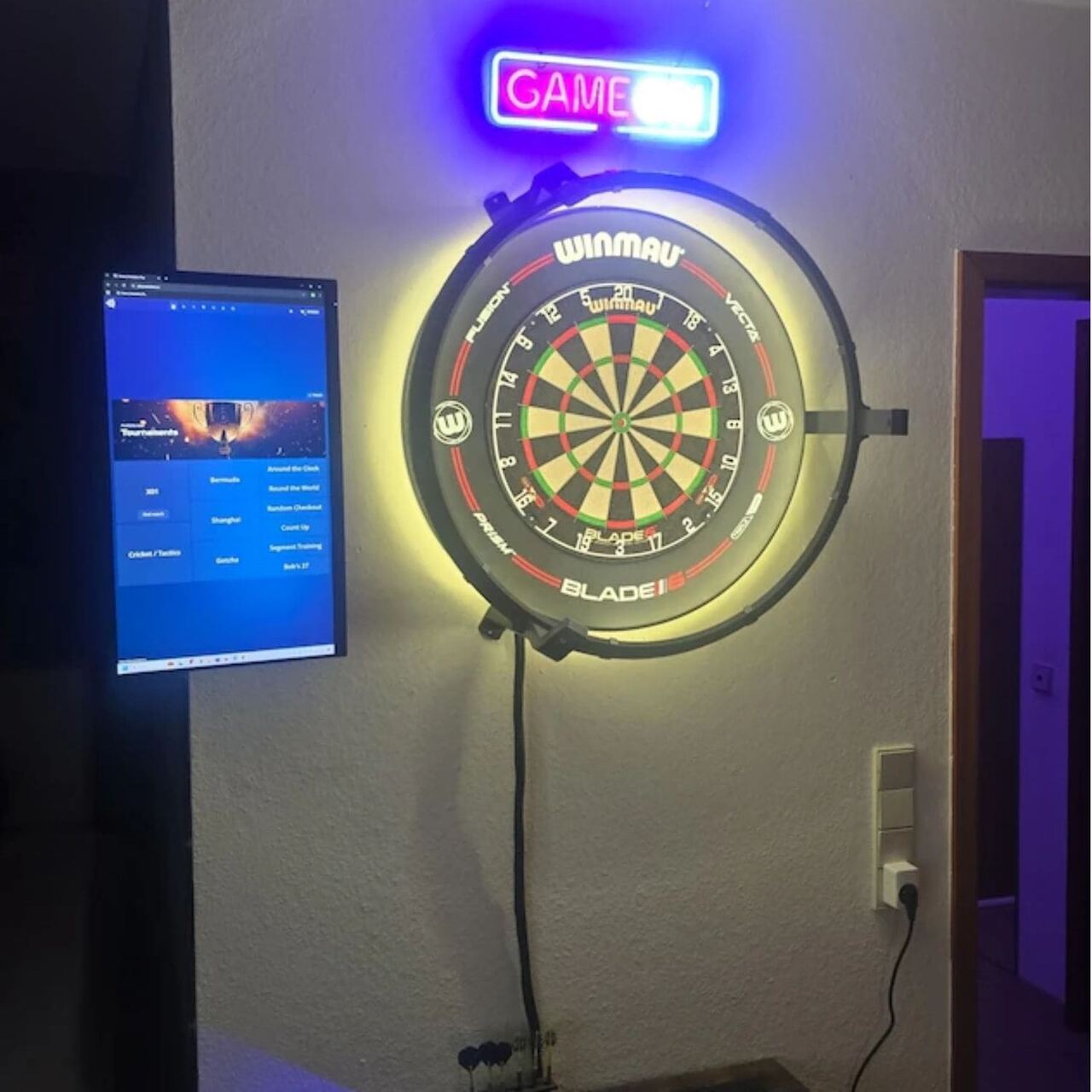 Autodarts Setup mit Winmau Blade Dartboard, LED-Ring, Neon Game On Schild und Autodarts Software auf dem Monitor